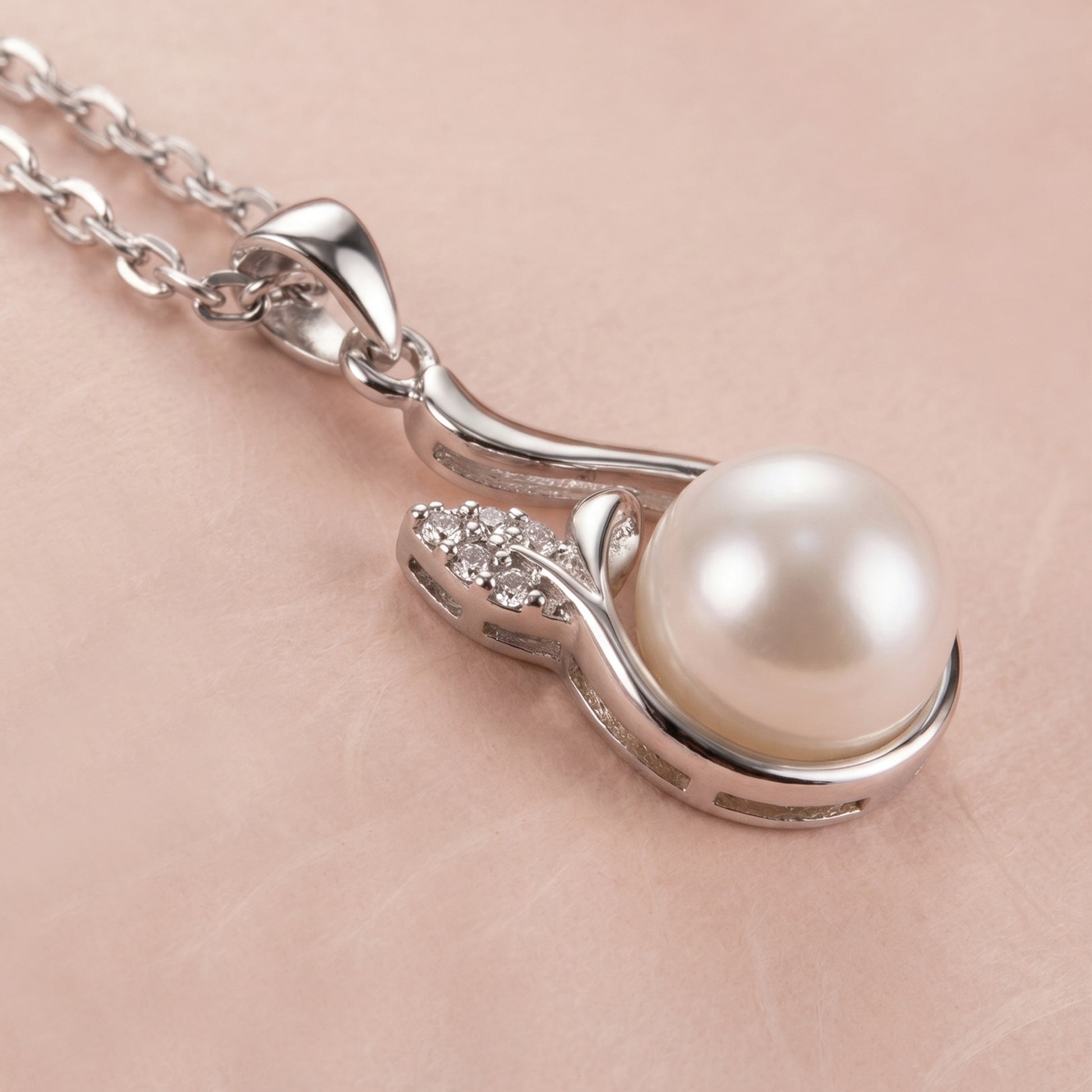 Close-up of a sterling silver necklace featuring a pearl and decorative elements