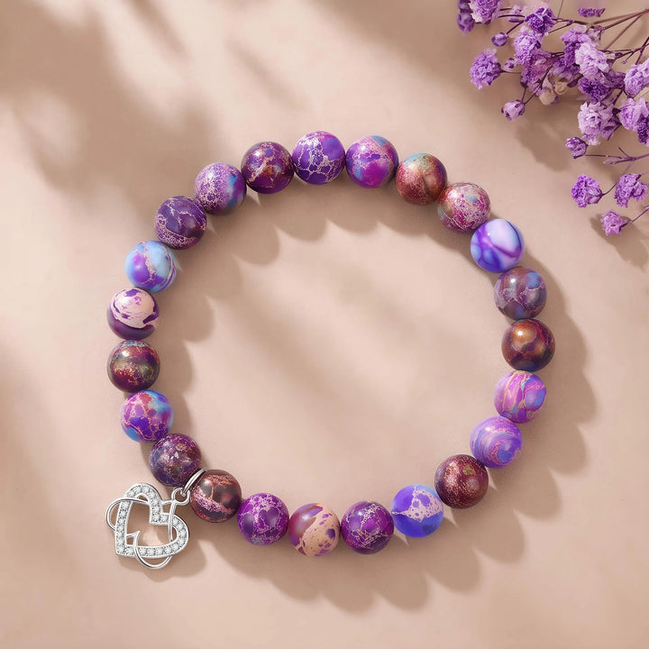Purple beaded bracelet with dangling silver heart charm