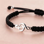 Close-up of black bracelet with treble clef charm