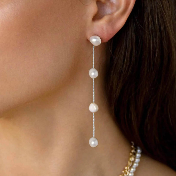 Model wearing sterling silver pearl drop earrings