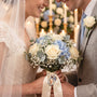 Bride and groom holding a bouquet with a charm attached