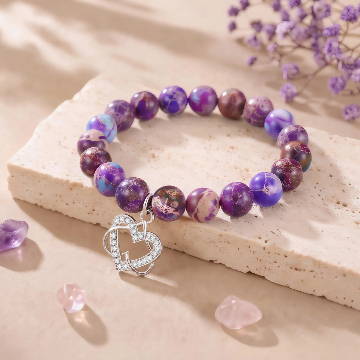 Purple beaded bracelet on light stone with silver heart charm