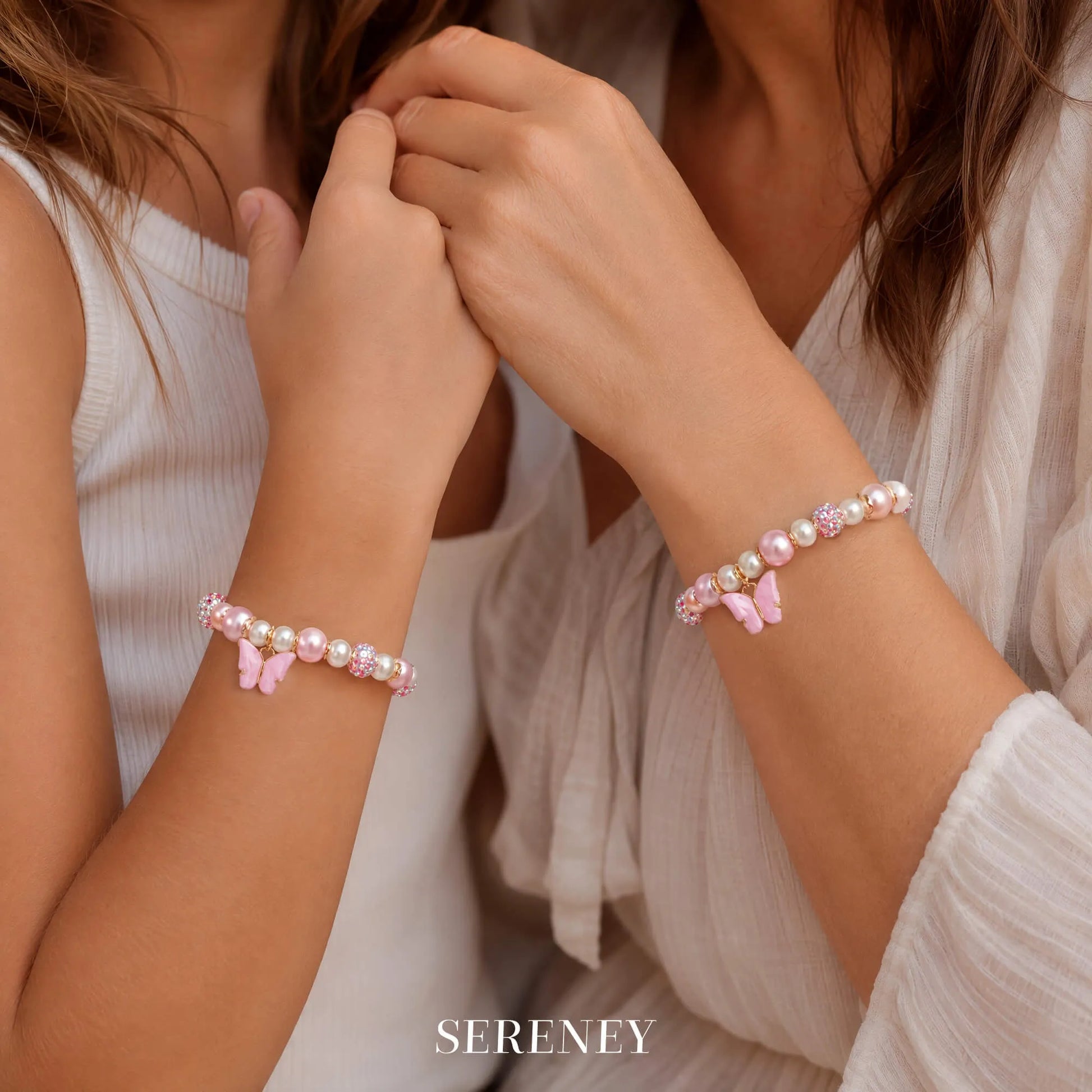 Two girls wearing matching butterfly bracelets