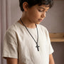 Boy wearing black cross necklace