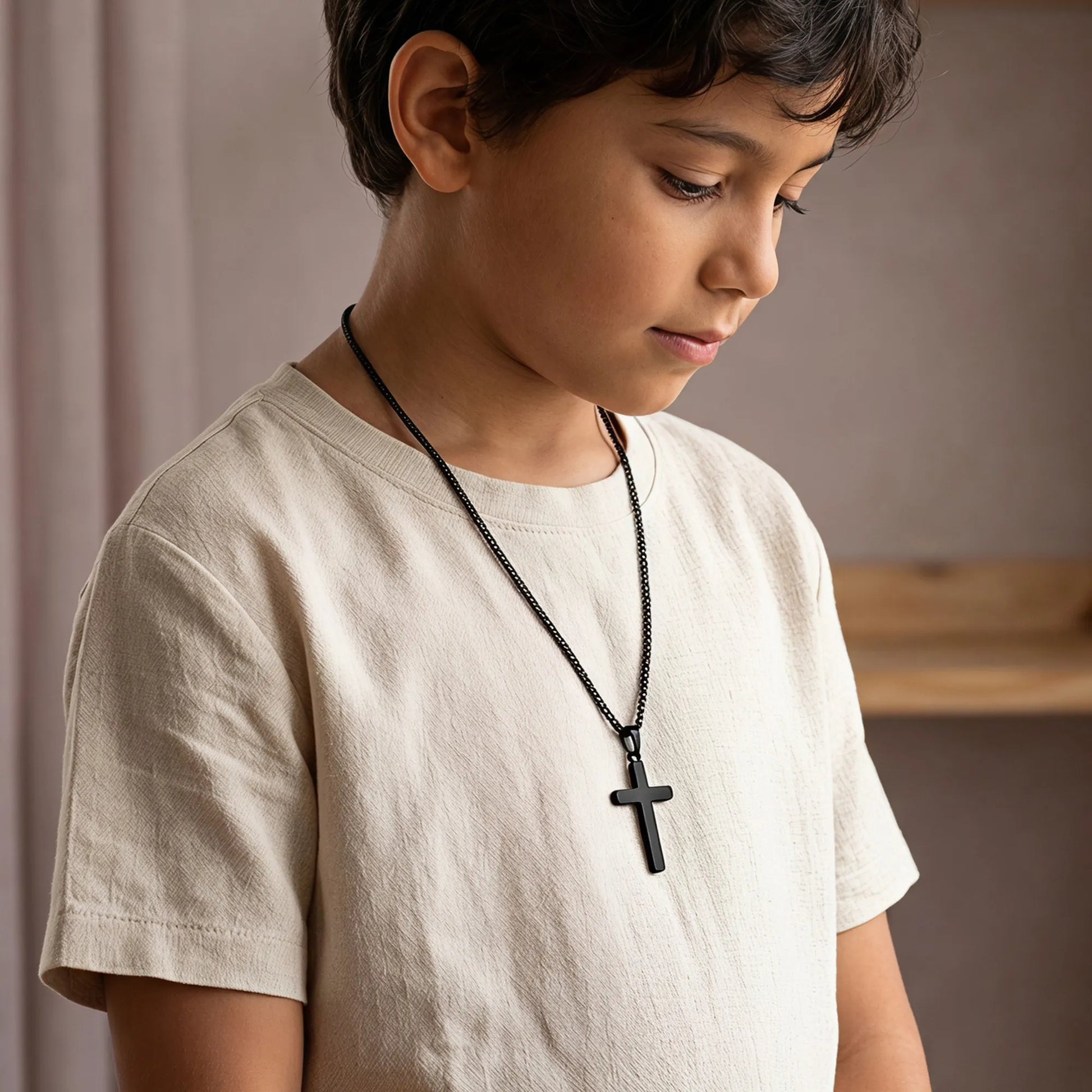 Boy wearing black cross necklace