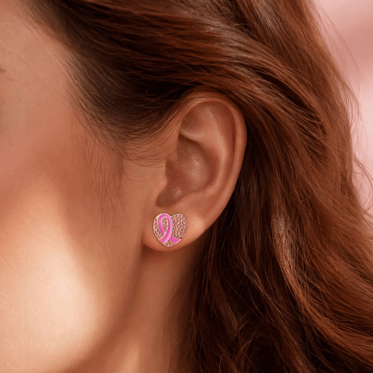 Heart-shaped pink ribbon stud earrings with rhinestone border