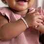 Little girl wearing pink pearl bracelet with number 2