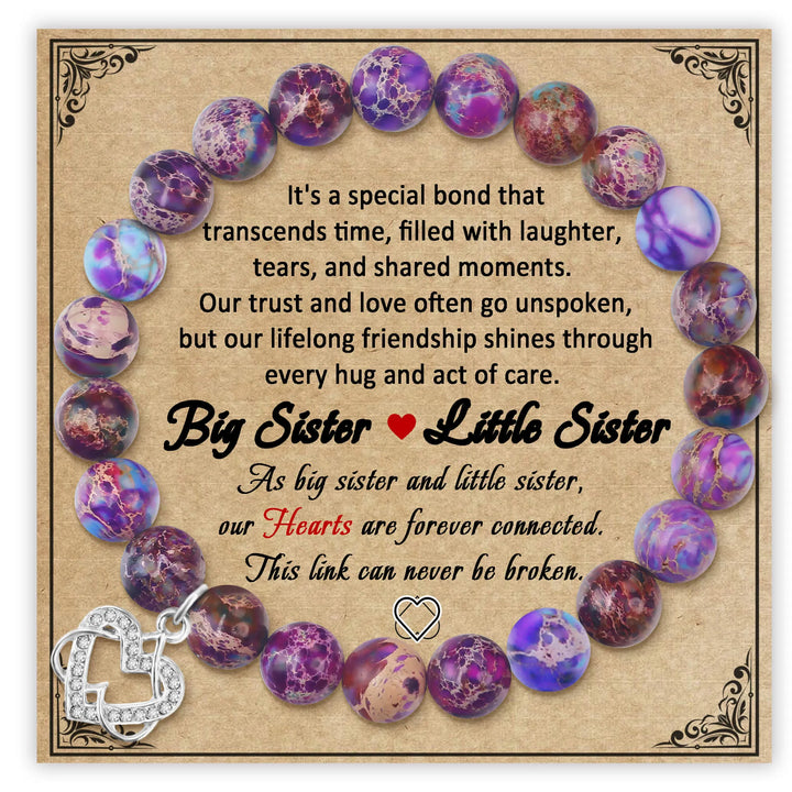 Purple beaded bracelet displayed on decorative card with silver heart charm
