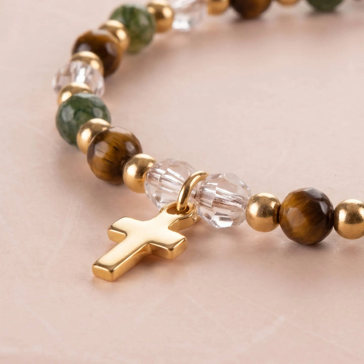 Detailed view of bracelet with cross charm and various beads