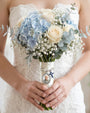 Bride holding a bouquet with a charm attached
