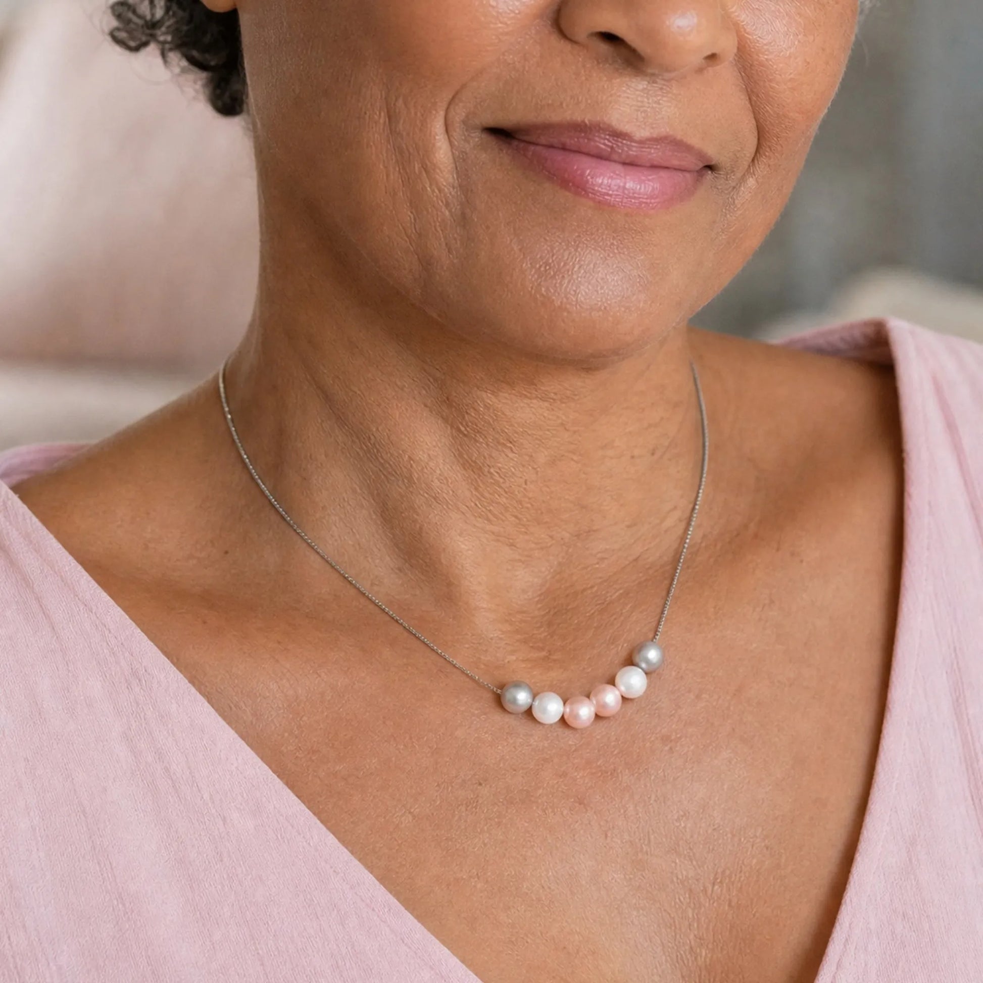 Woman wearing necklace with five crystal pearls