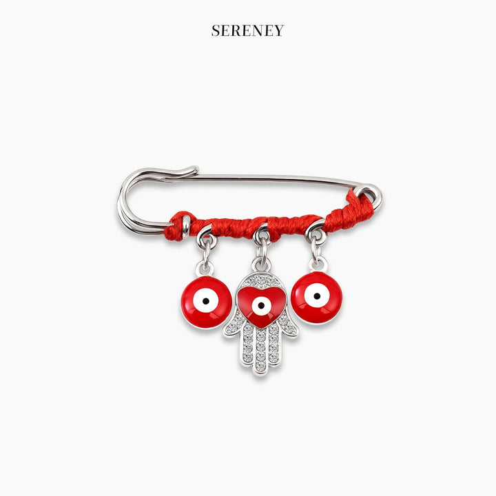 Close-up of silver Triple Protection Amulet Pin with red string