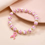 Pink ribbon charm bracelet with white beads, pink floral pattern, and gold beads