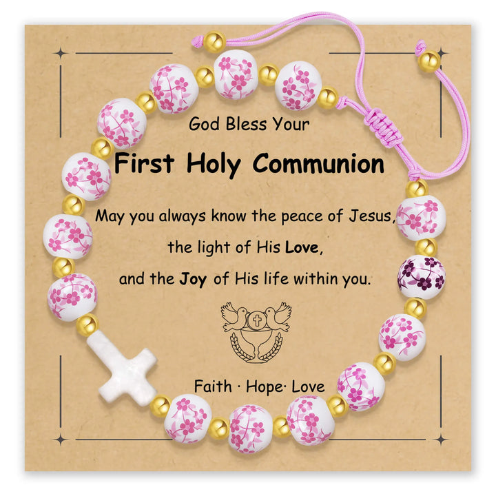 Bracelet featuring pink floral beads and a white cross on a card