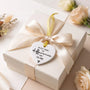 White ceramic heart keepsake with gold ribbon, shown as a gift tag