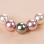 Close-up of three crystal pearls on a silver chain