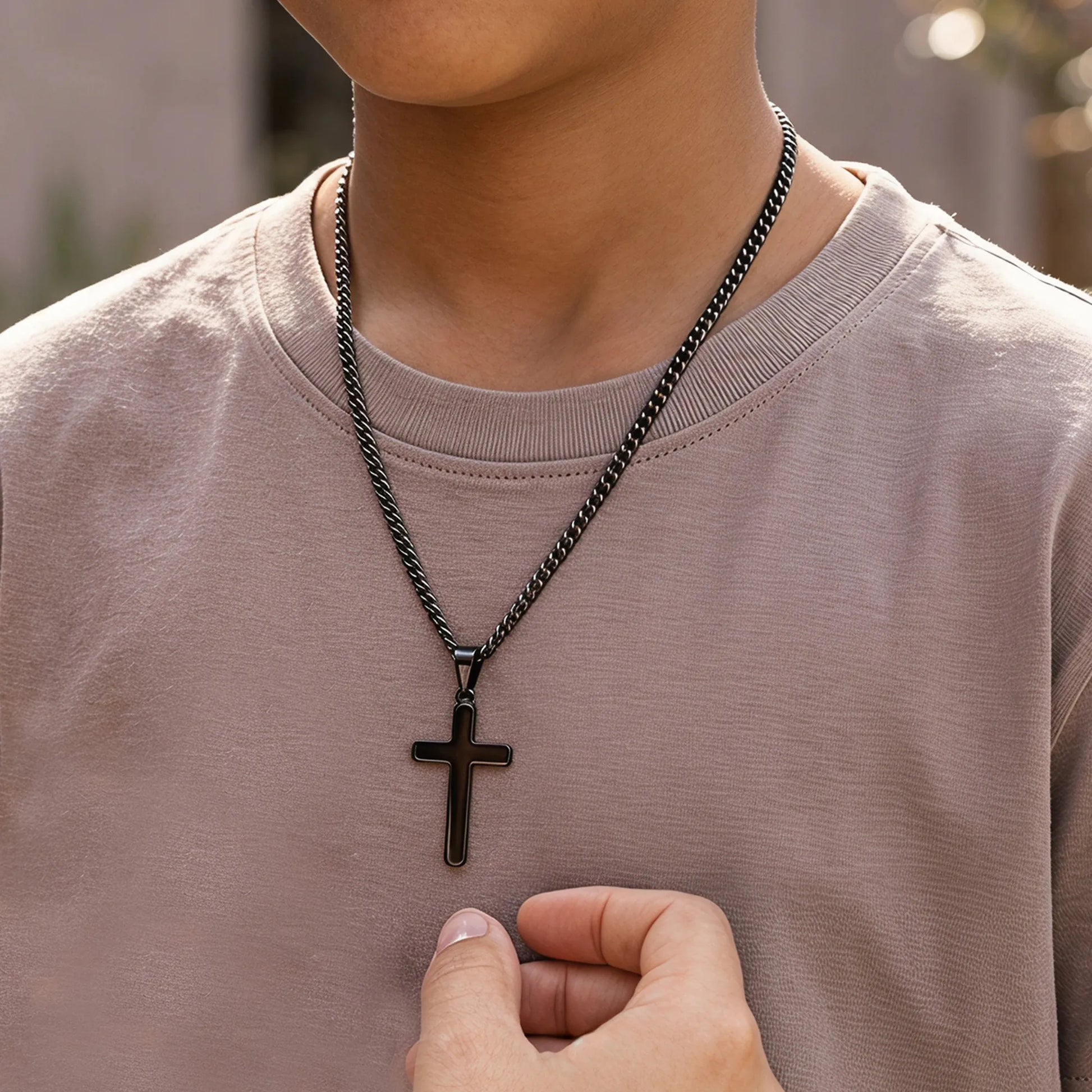Boy wearing black cross necklace outdoors
