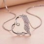 Close-up of silver heart necklace featuring infinity symbol and angel wing