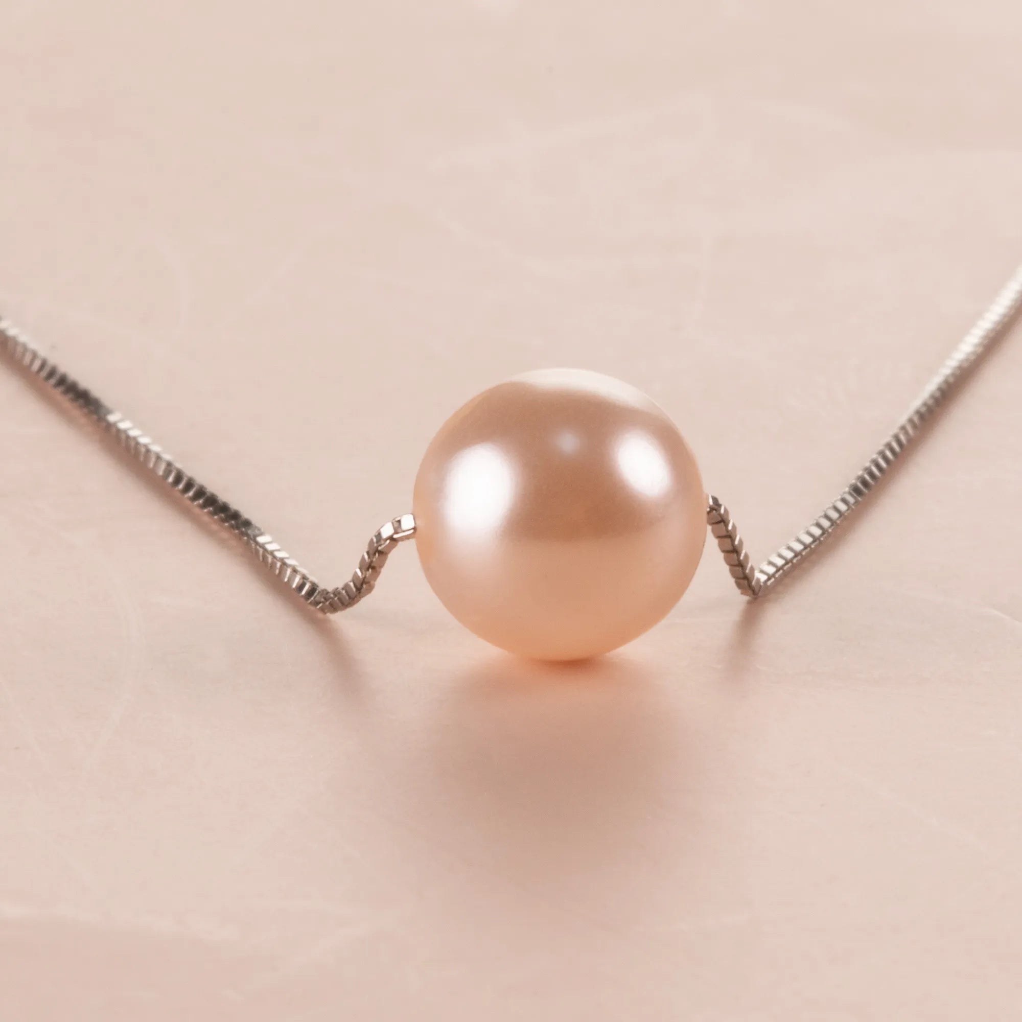 Close-up of a pink crystal pearl necklace on a light background