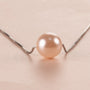 Close-up of a pink crystal pearl necklace on a light background