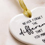 Close-up of ceramic heart keepsake with raised black lettering and gold ribbon