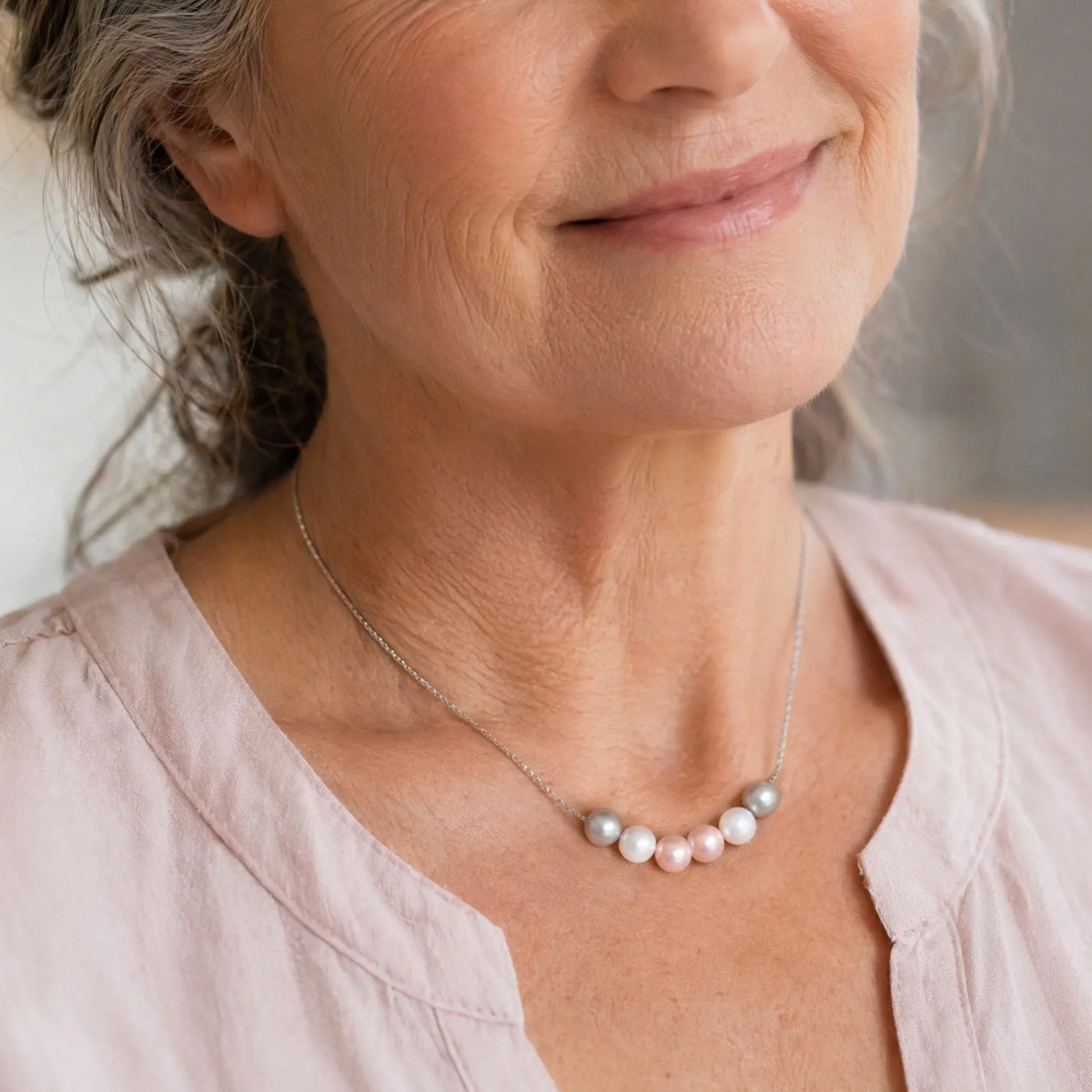 Woman wearing necklace with five crystal pearls
