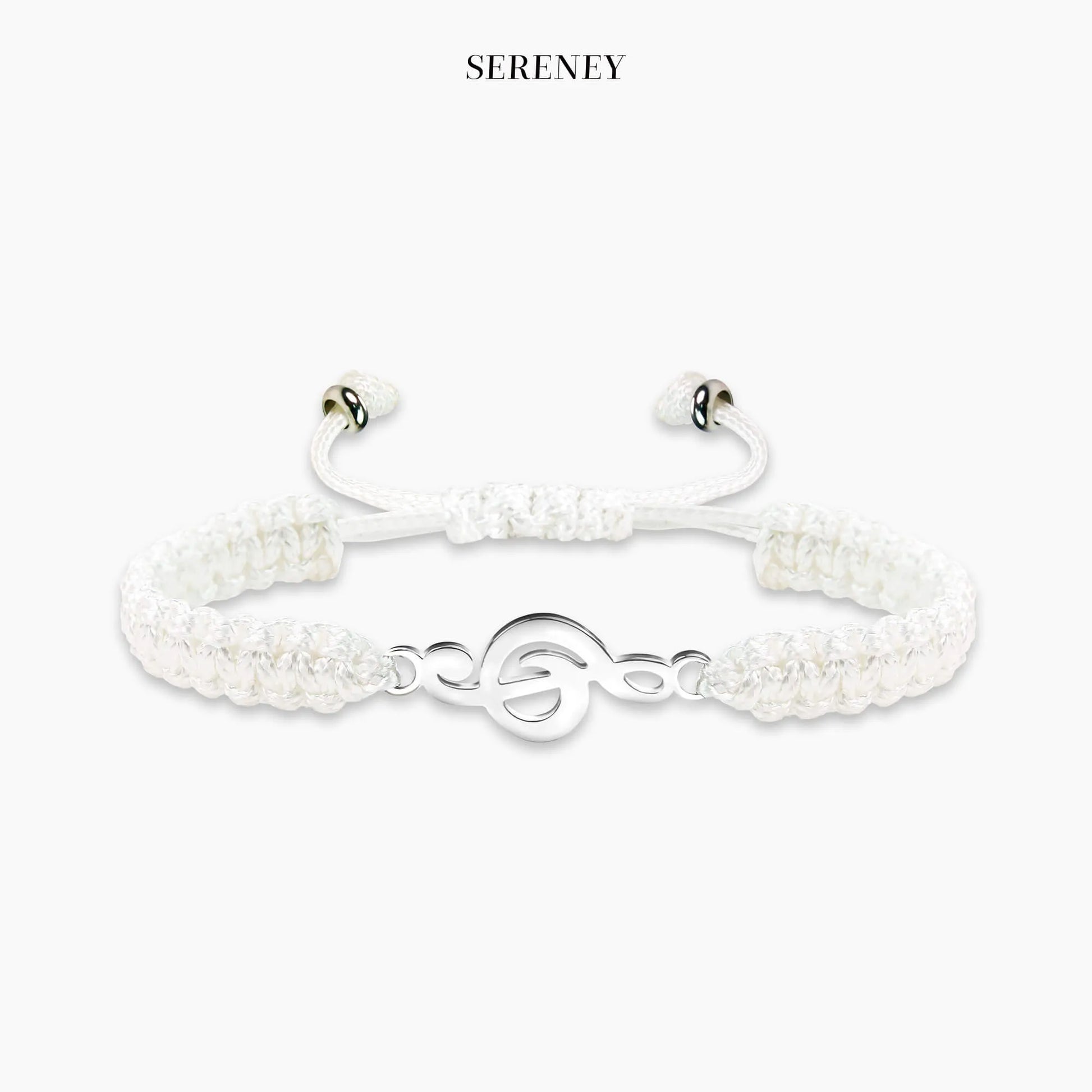 White bracelet with treble clef charm on a neutral background