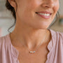 Woman wearing necklace with three crystal pearls