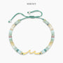 Ocean Wave Birthday Bracelet with wave charm and sea-toned beads