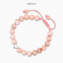 Pink zebra jasper bracelet with heart pendant on display